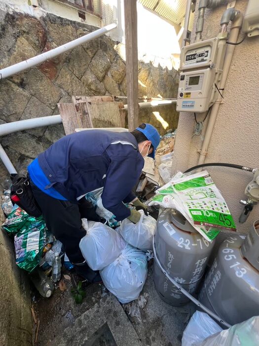 不用品を袋にまとめて搬出するスタッフ