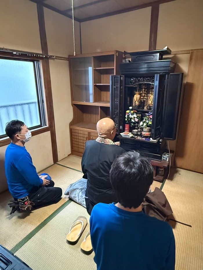 和室のお仏壇の前でご住職に読経いただき、スタッフが手を合わせる様子