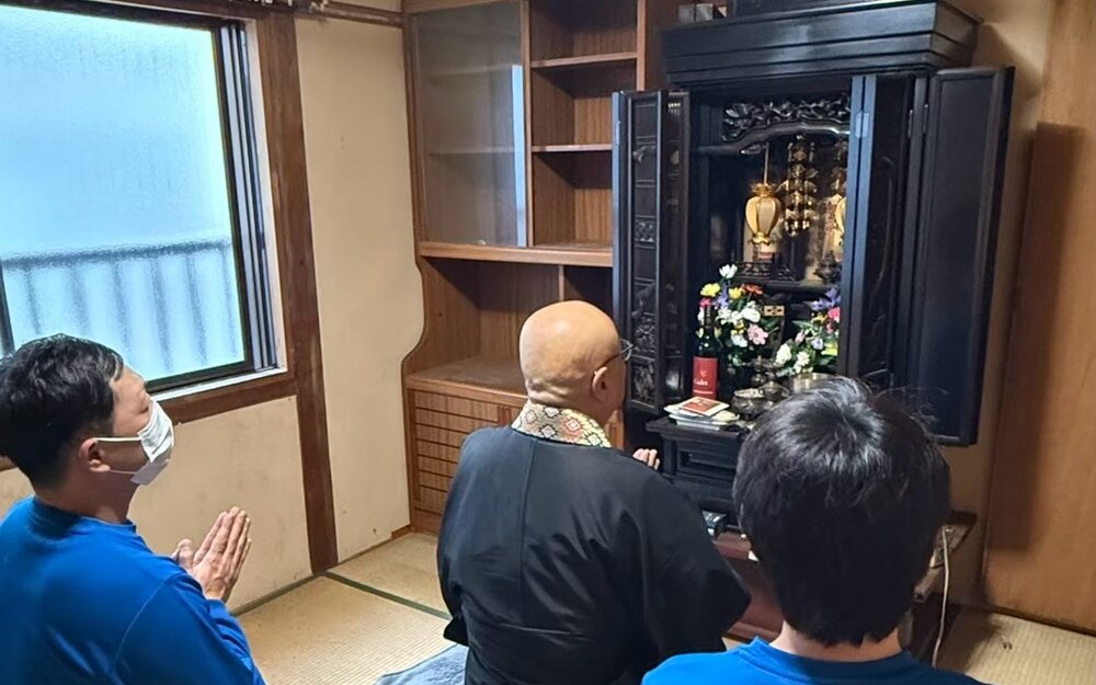 お仏壇の前でご住職に読経いただき、手を合わせる様子