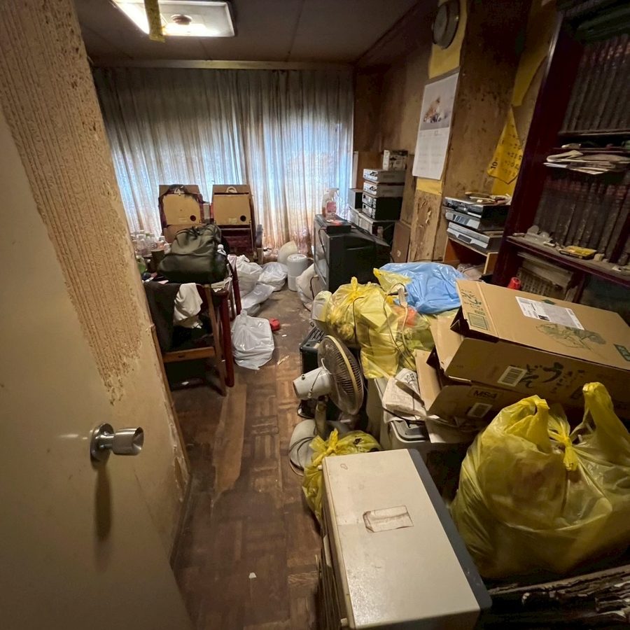作業前の洋室。床一面にお荷物が置かれている状態(池田市)